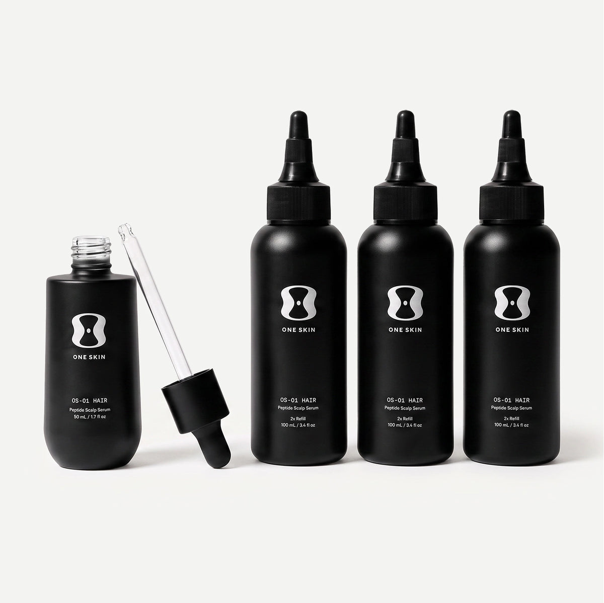 Set of black hair serum bottles with dropper on a light beige background. Contains descriptive text stating Bottle size may vary. The 6-month supply will always come with 150mL of the OS-01 HAIR serum.
