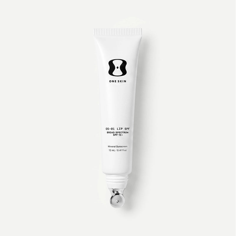 A white squeeze tube of ONE SKIN LIP SPF 15 with a silver applicator, shown against a light gray background.