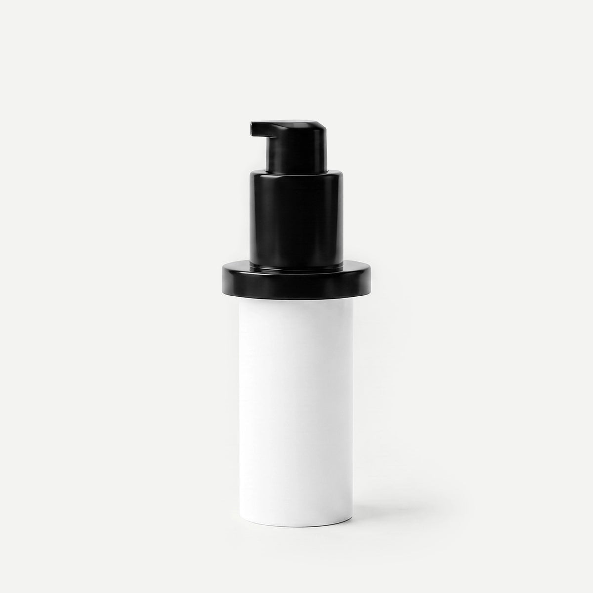 White cylindrical container with a black pump on a beige background