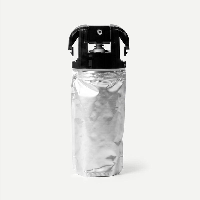 Silver refill package with black cap on a light beige background