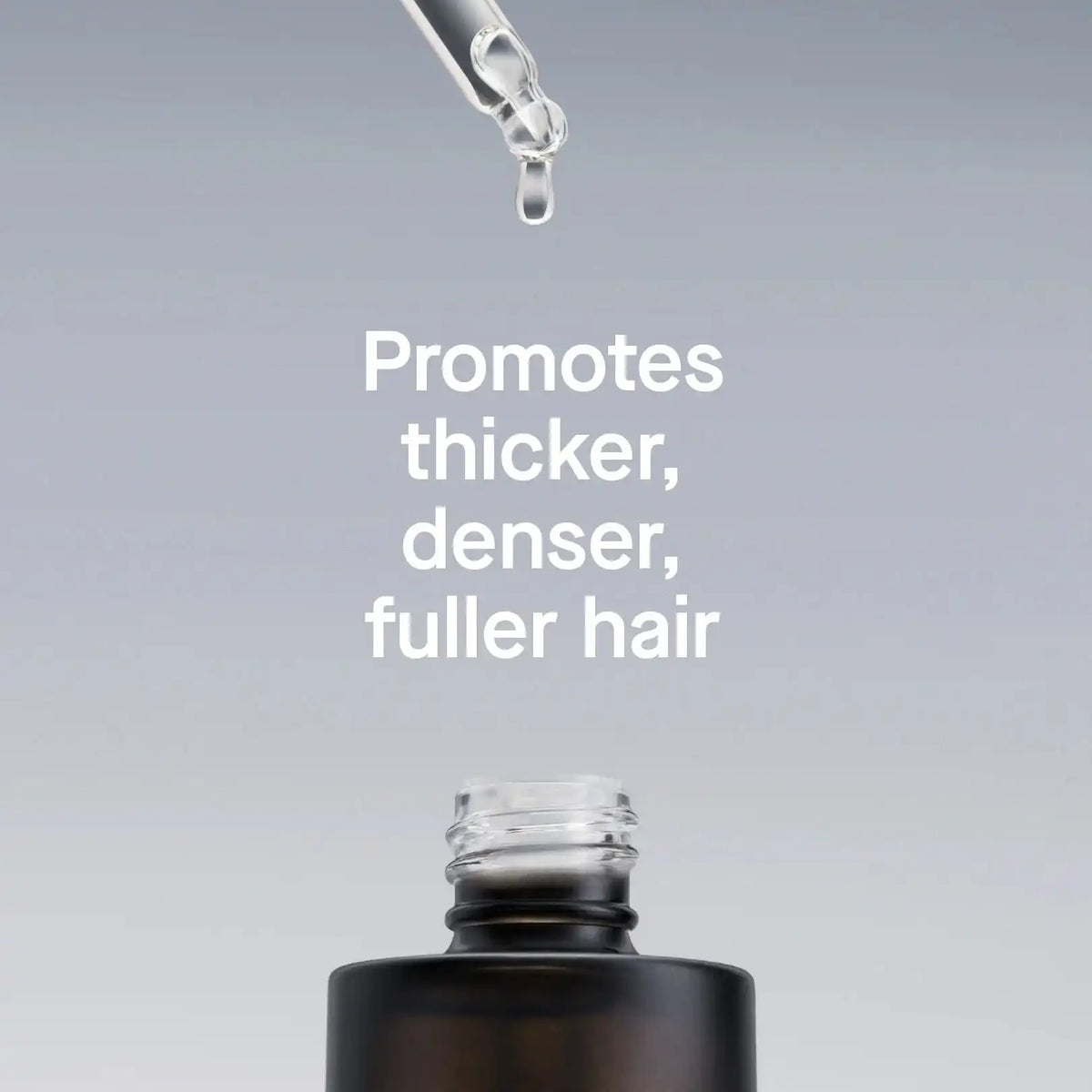 Hair product dropper with text promoting thicker, denser, fuller hair on a gray background